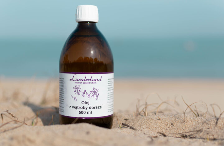Butelka oleju z wątroby dorsza Lunderland na plaży.